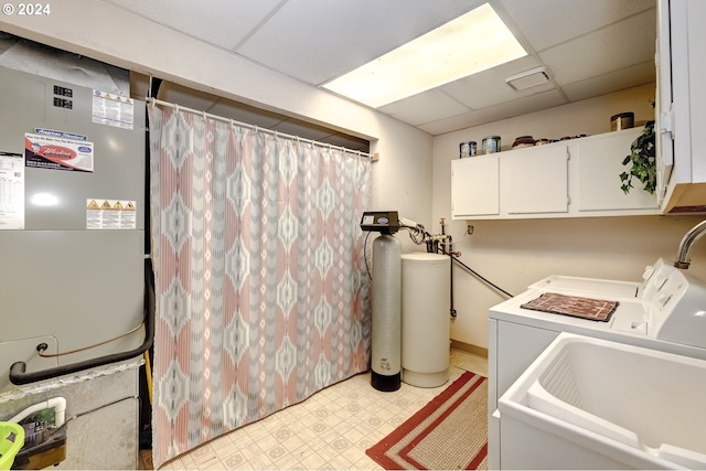 washroom with sink, cabinets, light tile floors, and separate washer and dryer