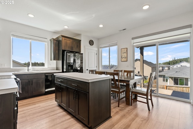 kitchen featuring a sink, black appliances, light countertops, plenty of natural light, and recessed lighting