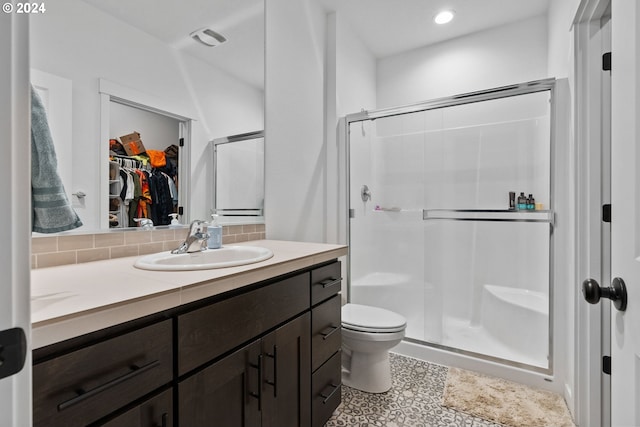 bathroom with a shower stall, toilet, tasteful backsplash, a walk in closet, and vanity