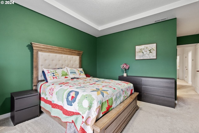 bedroom featuring a textured ceiling and light carpet