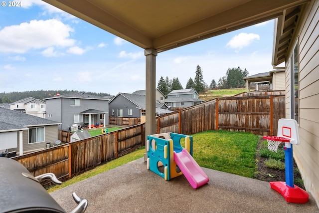 view of play area featuring a lawn and a patio area