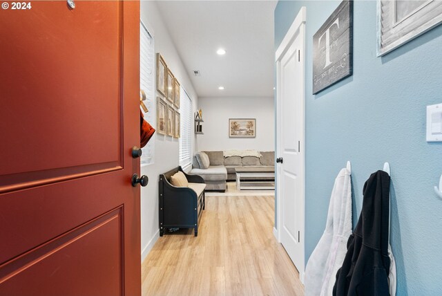 corridor with light wood-type flooring, recessed lighting, and baseboards