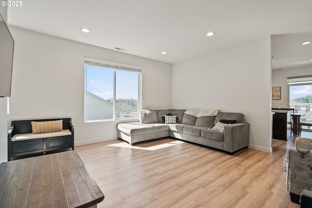 living area with light wood-style flooring, recessed lighting, and baseboards