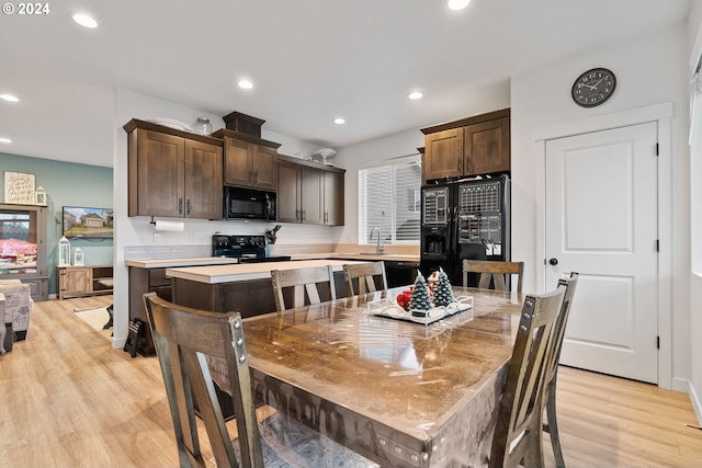 dining space with sink and light wood-type flooring