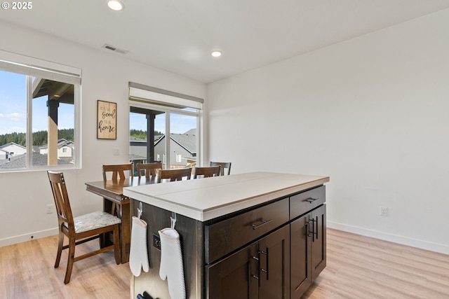 dining area with baseboards, light wood-type flooring, and recessed lighting