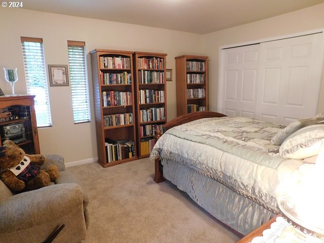 bedroom with light carpet and a closet