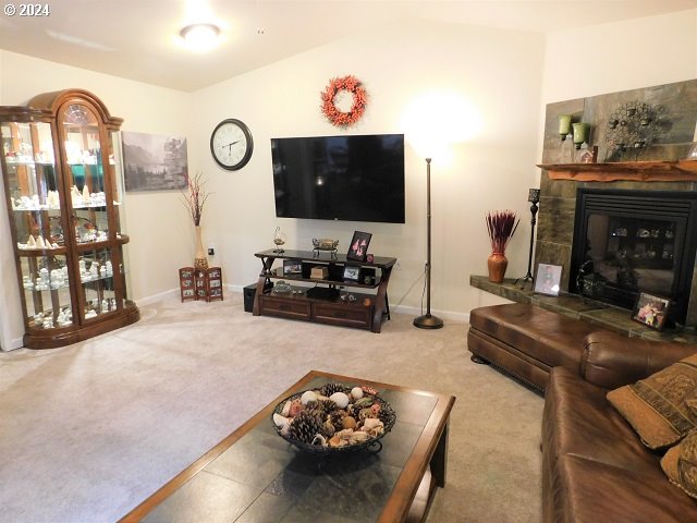 living room with carpet and a tiled fireplace