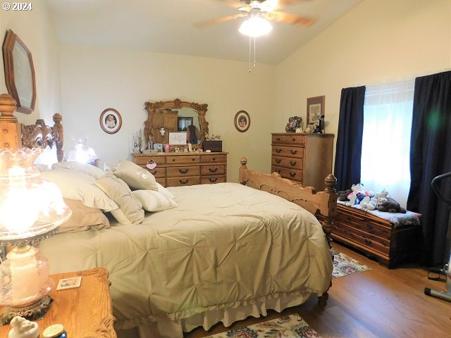 bedroom with vaulted ceiling, ceiling fan, and hardwood / wood-style flooring