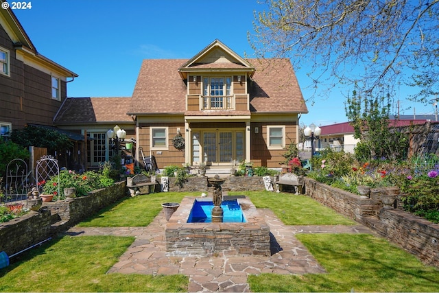 back of property with fence, a lawn, and roof with shingles