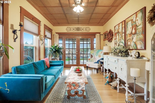 sitting room with an ornate ceiling, french doors, crown molding, and wood finished floors