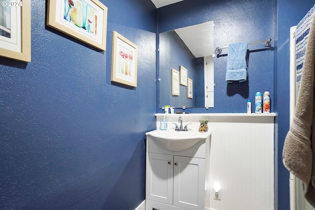 bathroom with a textured wall and vanity