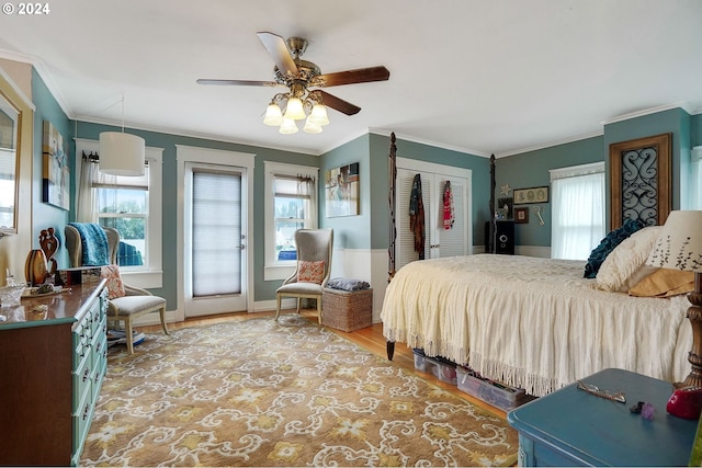 bedroom with a ceiling fan, a closet, crown molding, and wood finished floors