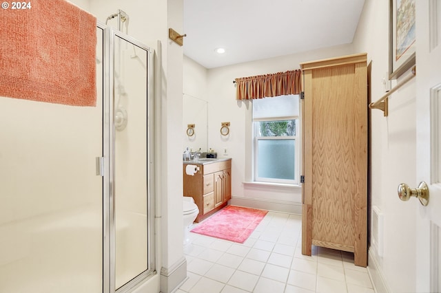 bathroom featuring toilet, a stall shower, tile patterned flooring, and vanity