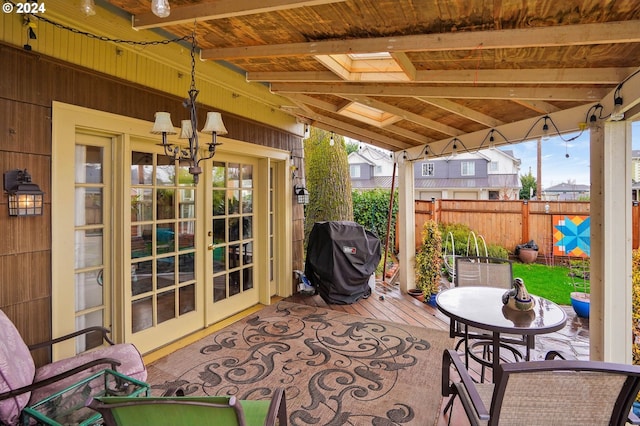 exterior space with a healthy amount of sunlight, vaulted ceiling with skylight, and a chandelier