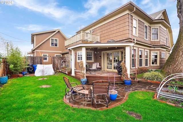 rear view of house featuring a patio, a lawn, fence, and a balcony