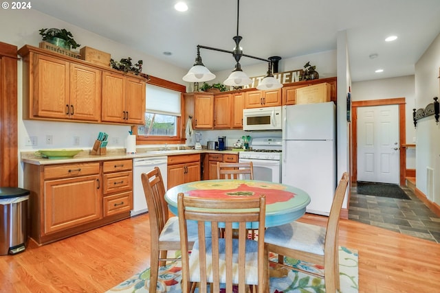 kitchen with recessed lighting, white appliances, light countertops, light wood finished floors, and pendant lighting