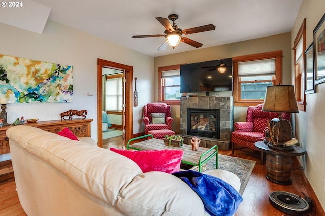 living area with a fireplace, baseboards, and wood finished floors