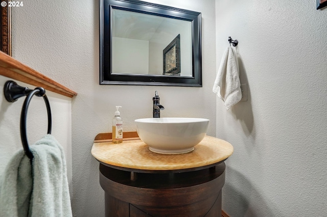 bathroom with a textured wall and vanity