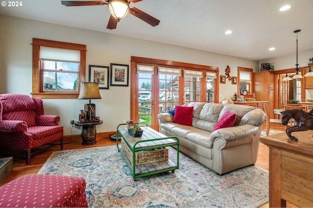 living room featuring light wood-style floors, a wealth of natural light, baseboards, and recessed lighting