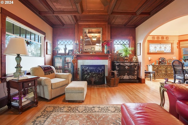 living area featuring wooden ceiling, coffered ceiling, crown molding, and wood finished floors