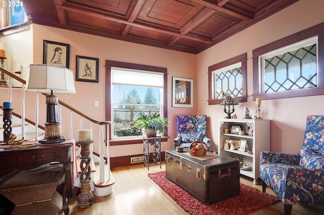 sitting room featuring ornamental molding, wood finished floors, coffered ceiling, baseboards, and stairs