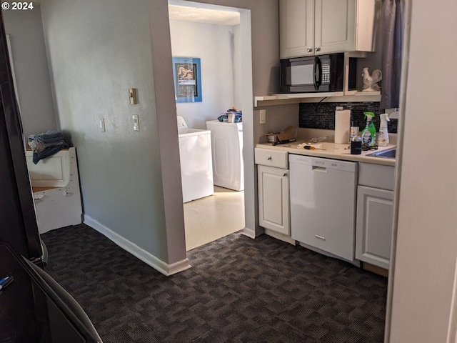 kitchen with white cabinetry, backsplash, white dishwasher, and washing machine and clothes dryer