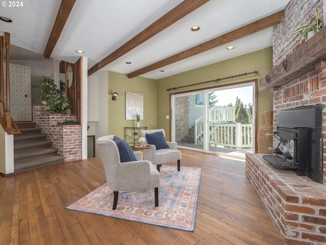 living area with beamed ceiling, stairway, and hardwood / wood-style flooring