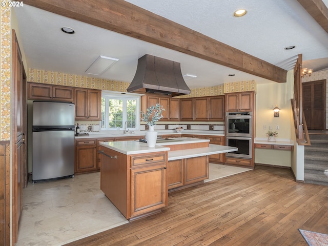 kitchen featuring a center island, light countertops, custom range hood, appliances with stainless steel finishes, and beamed ceiling