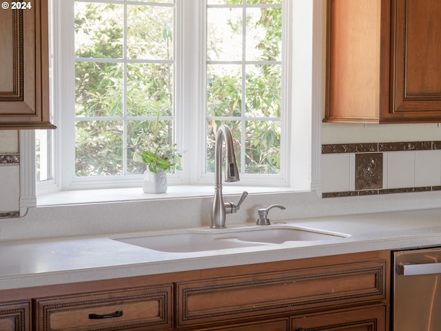 room details with brown cabinetry, light countertops, and a sink