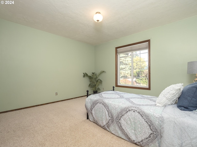 bedroom with a textured ceiling, carpet flooring, and baseboards