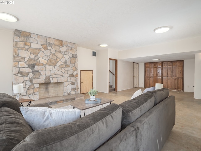 living area featuring visible vents, concrete floors, stairway, and a fireplace