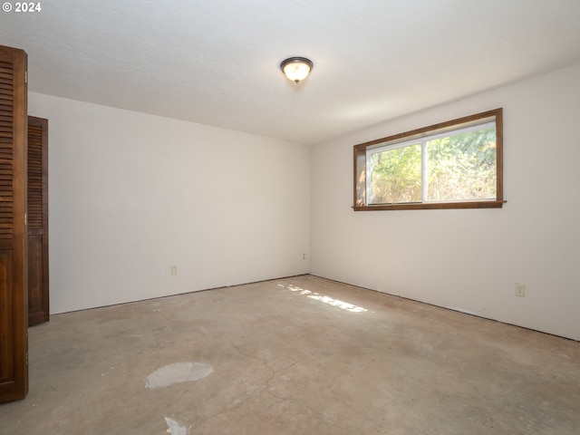 empty room with unfinished concrete flooring