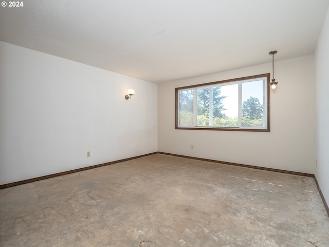 unfurnished room with baseboards