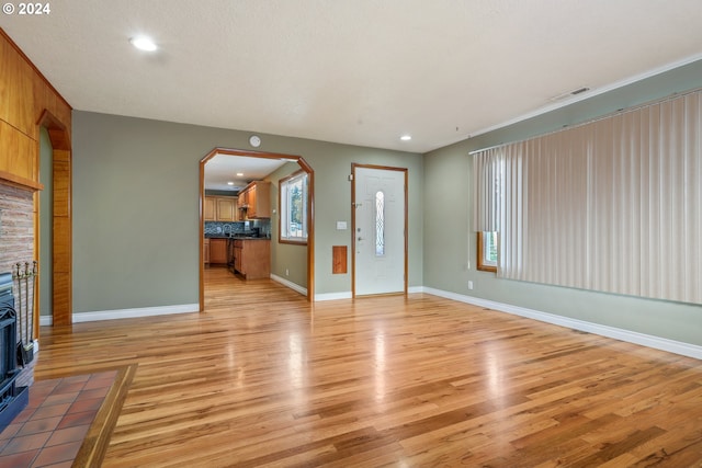 unfurnished living room featuring light hardwood / wood-style floors and a textured ceiling