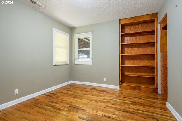 unfurnished bedroom with a textured ceiling and light hardwood / wood-style floors