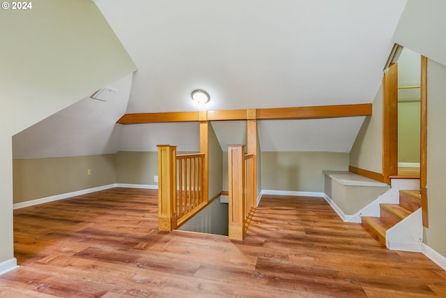 additional living space with hardwood / wood-style floors and lofted ceiling