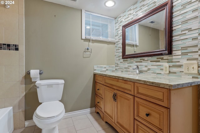 bathroom with decorative backsplash, vanity, a bath, tile patterned flooring, and toilet