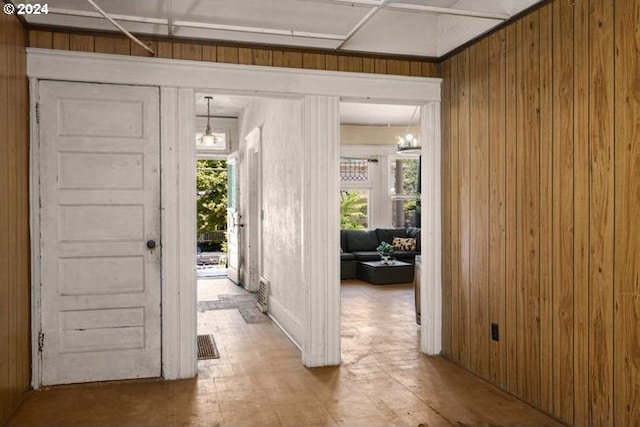 doorway with a wealth of natural light and wood walls