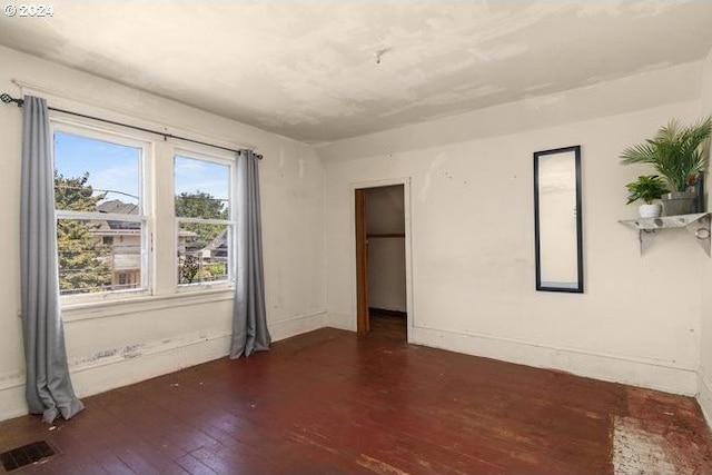 spare room featuring dark wood-type flooring