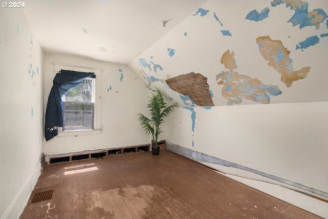 unfurnished room featuring hardwood / wood-style flooring and vaulted ceiling