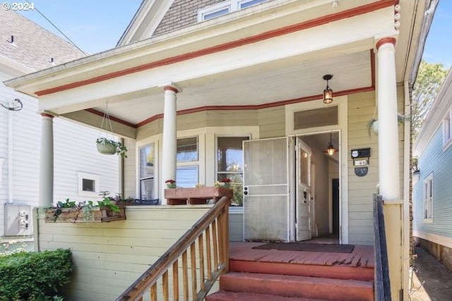 view of exterior entry featuring covered porch