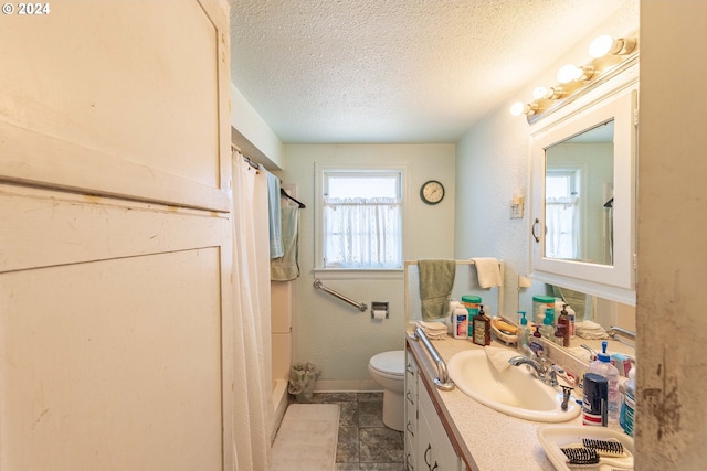 bathroom with vanity, curtained shower, a textured ceiling, and toilet