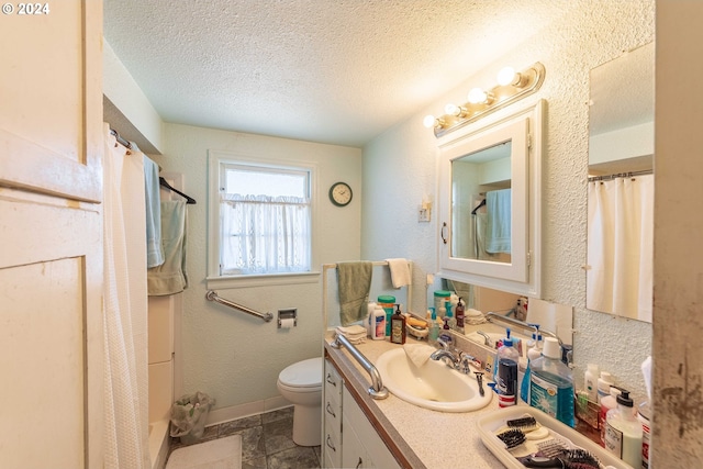 bathroom with vanity, a textured ceiling, and toilet