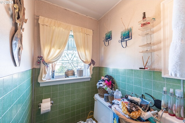 bathroom featuring toilet and tile walls