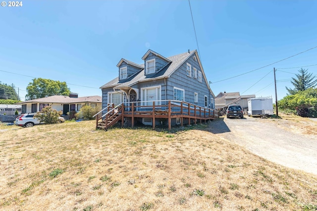 view of front facade featuring a deck and a front lawn