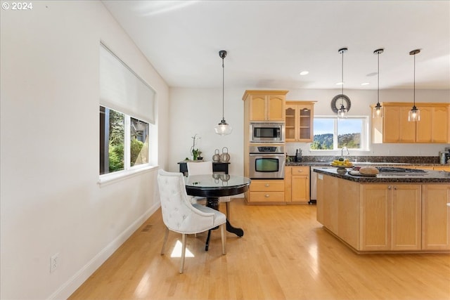 kitchen featuring light brown cabinetry, appliances with stainless steel finishes, plenty of natural light, and light hardwood / wood-style flooring