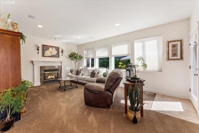 carpeted living room with a premium fireplace