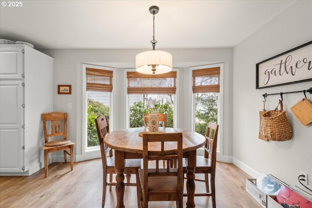 dining area with light wood finished floors and baseboards