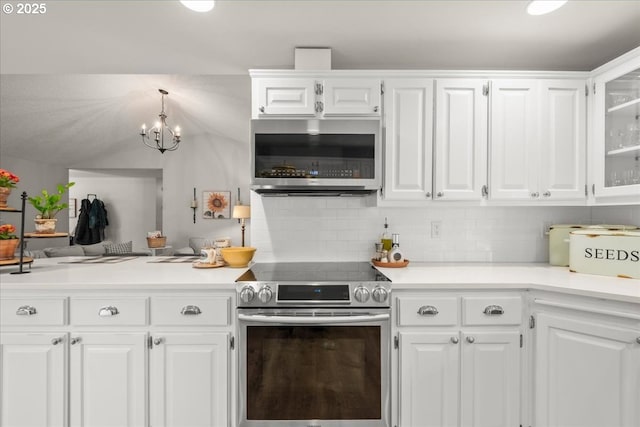 kitchen with appliances with stainless steel finishes, light countertops, white cabinets, and glass insert cabinets