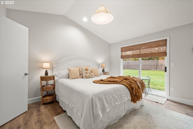 bedroom with access to exterior, vaulted ceiling, baseboards, and wood finished floors